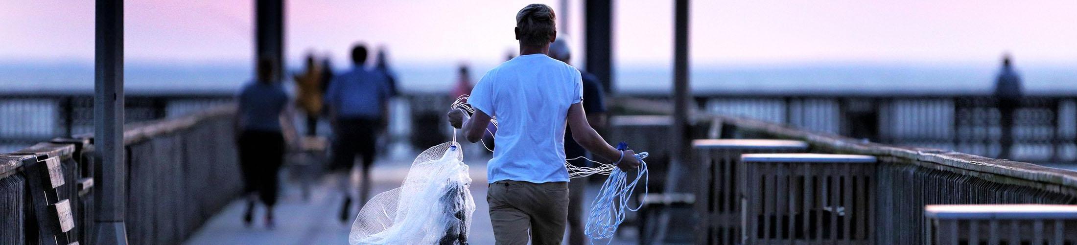 Male carrying cast nets on Fair Hope Pier located on the Gulf Coast.