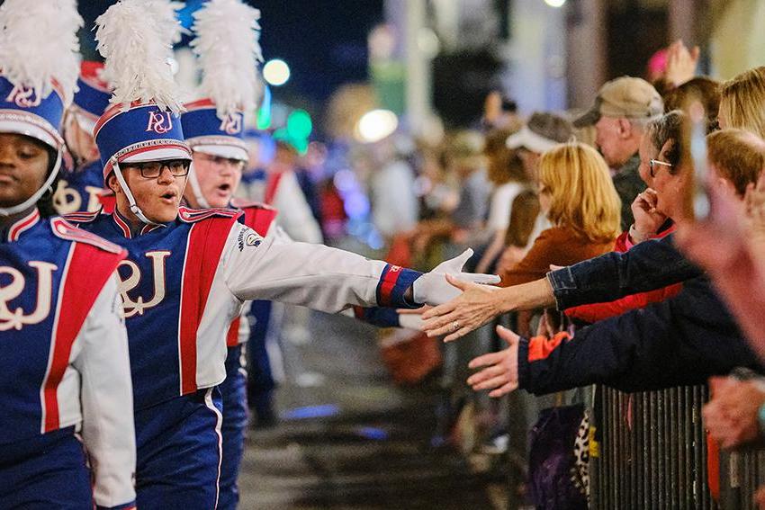 Jaguar Marching Band giving high fives to audiences